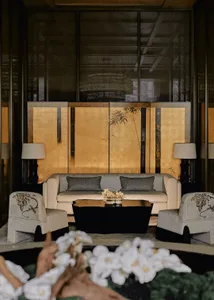 Comfortable and inviting living space with a gold wall, modern furniture, and natural light