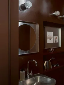 Bathroom with a brown color scheme, featuring a sink, mirror, and brown cabinet, in a modern style with dim lighting