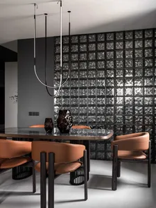 Dining room with a glass table and chairs, surrounded by a modern space with a black and white color scheme and dim lighting