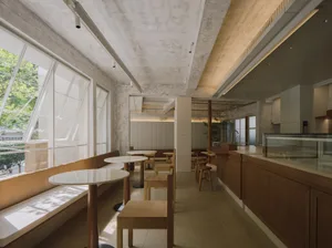 Bright and inviting restaurant interior with wooden furniture, white walls, and natural lighting