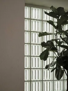 A cozy room with a large window, a potted plant, and natural light