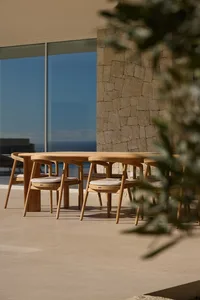 Cozy dining space with a glass wall, wooden dining table, and natural light from the outdoors