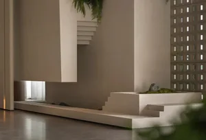 A minimalist white staircase in a bright and open space with a white wall on either side