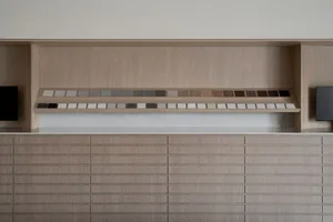 A modern kitchen with a wood cabinet, patterned tiles, and open drawers, featuring a functional and organized design