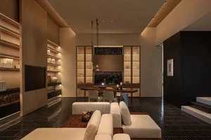 Comfortable living space with a white couch, brown dining table, and various decorative items, well-lit and inviting