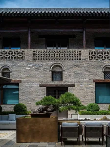 A stone building with a brick facade, adorned with windows, set against a city backdrop