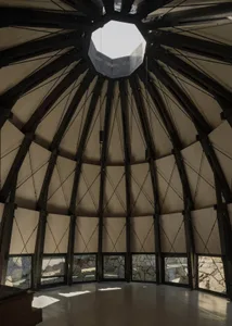 A large, airy room with a dome-shaped ceiling, wooden walls, and natural light, showcasing a modern and minimalist style