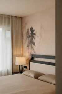 一間現代的臥室，床、燈和一幅充滿自然風情的牆畫，場景充滿柔和的溫暖光線