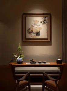 A cozy living room or dining area with a wooden table, chairs, couch, and chair, set with cups and a vase, creating a warm and inviting atmosphere