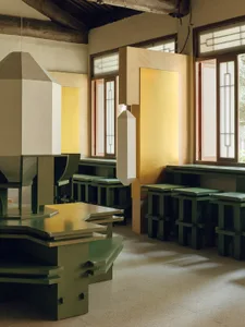 A restaurant with a yellow and green color scheme, featuring a dining area, bar, and decorative elements, with a mix of natural and artificial lighting