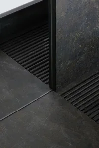 A metal staircase with a metal door at the bottom, set in a commercial or industrial space