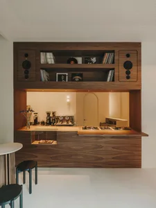 Warm and cozy kitchen with a wooden cabinet, glass door, and counter featuring a microwave, surrounded by a dining area with a table and chairs