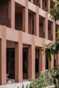 A large building with a brown brick exterior, stone, and wood elements, featuring arched windows and a mix of traditional and modern architectural styles