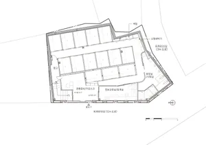 A modern office building floor plan with a large central room and smaller rooms surrounding it, drawn in black and white with dim lighting