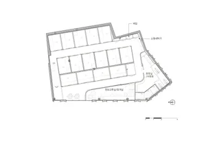 Black and white floor plan of a large room with a long hallway and a staircase leading to the upper floor, showing kitchen and dining areas with natural light from windows