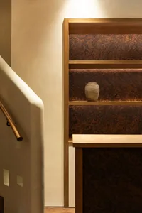 A traditional staircase with a wooden railing in a residential setting, featuring natural lighting and a calm atmosphere