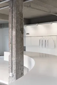 一間清潔和簡約的衣物店，白色襪子排列成圓形圖案掛在白色牆上