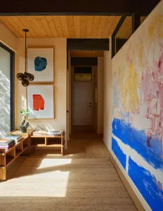 Cozy living room with a blue and white color scheme, hardwood floor, and natural light from a window