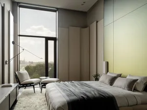 Cozy modern bedroom with a gray bed, chair, and natural light from a large window