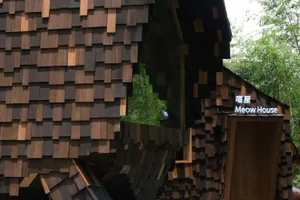 A modern building with a large wooden structure and wooden roof, showcasing its design and natural lighting
