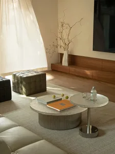 A modern living room with a wooden floor, a large couch, a coffee table, and a TV mounted on the wall, with vases and a comfortable atmosphere