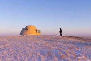 A serene and picturesque modern house with a dome-shaped structure blending traditional and contemporary styles, surrounded by a grassy area