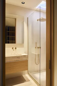 Bathroom with a glass shower door, sink, and mirror, featuring a modern design