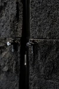 Dark storage space with a stone wall, metal shelves, and a moody atmosphere