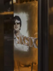 一張木門照片，一個白色標牌標示著 SIX，背景是 neutrality