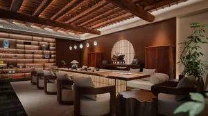 Warm and inviting living space with a wooden floor, a bar area, dining table, chairs, couch, and potted plant