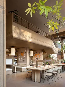 A warm and inviting living space with a wooden floor, a dining table, kitchen area, and staircase, filled with furniture and decorative items