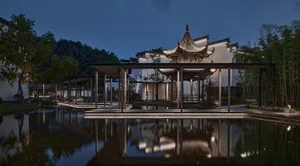 oriental-style building with a pagoda roof, water feature, and surrounding garden