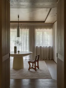 一間充滿溫暖氣氛的客廳，木地板、餐桌和白色窗簾，營造舒適的氛圍