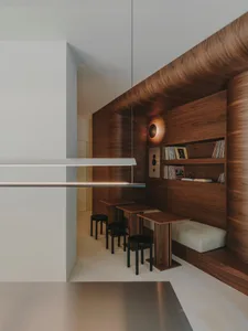 A warm and inviting room with wooden walls and floors, featuring a dining table, chairs, couch, and bookshelf