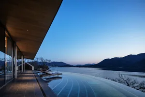 一片祥和的池塘景色，後方有木造建築，充滿放鬆的氣氛