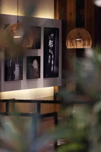 Warm and inviting restaurant interior with wooden furniture, natural light, and Asian-style artwork on the walls