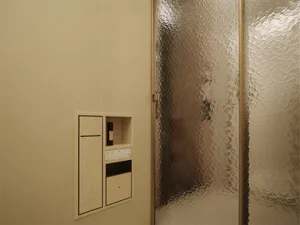 Bathroom with a glass shower stall, tan color scheme, and bright lighting