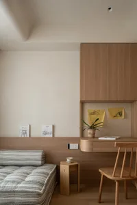 Comfortable living space with wooden floors and walls, a couch, dining table, chair, and potted plant, well-lit for a warm atmosphere