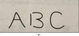 A dimly lit room with a white wall and a black letter A on it, with a bed in the background