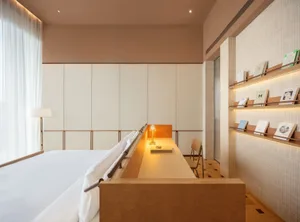 一間現代床房室，床和書桌，木和白色床单，在充足天然光線下的光明空間中，透過窗戶自然光線