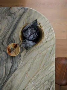 A photograph of a marble countertop with a bowl placed on it, set in a kitchen or dining area with natural or ambient lighting