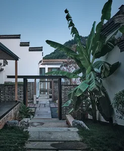 A dimly-lit patio area with a stone floor and stone wall, surrounded by a stone wall