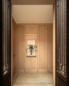 A dimly lit hallway with wooden walls and a door, creating a warm and natural atmosphere