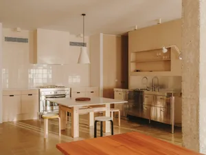 Modern kitchen and dining area with a wooden table, kitchen island, and natural light from windows