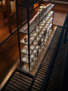 A cozy living space with a wooden shelf displaying bottles, soft warm lighting, and a inviting atmosphere