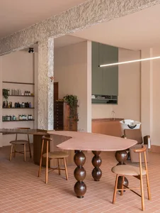 Spacious modern dining room with a large dining table, wood and stone materials, and a well-lit atmosphere