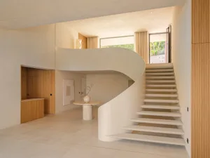 A modern house with a white marble staircase, open space, and white color scheme