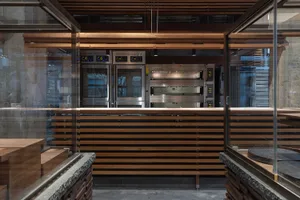 Bright and inviting kitchen with a large window, wood counter, and stainless steel oven, refrigerator, and appliances