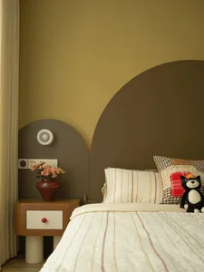 Cozy bedroom with a striped bed, a nightstand, and a potted plant, dimly lit for a relaxing atmosphere