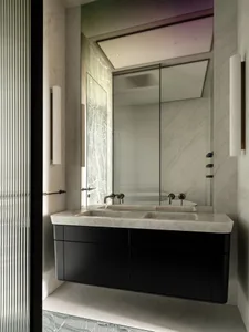 Classic bathroom with a marble sink, glass shower, and black and white color scheme, featuring dim lighting for a cozy atmosphere